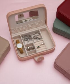 Porta-joias quadrado, fechado, feito de couro sintético branco, sobre uma superfície neutra.