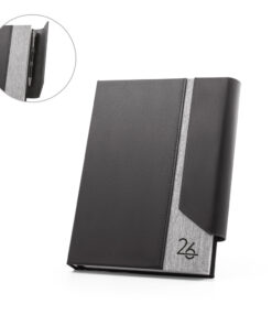 Agenda A5 executiva na cor preta e cinza, feita com PU e PET reciclado, mostrando detalhe do fecho magnético e suporte para esferográfica.