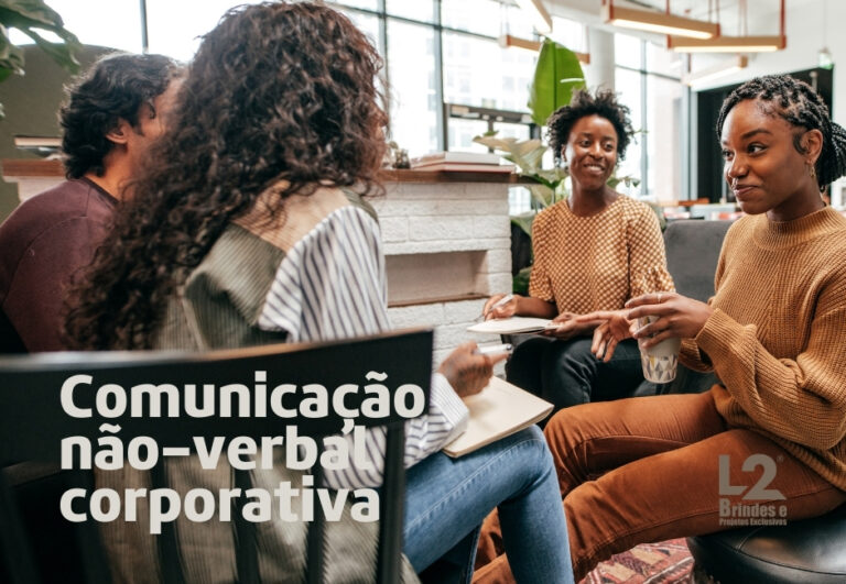 Grupo diversificado de colegas de trabalho em uma conversa descontraída no escritório, ilustrando a comunicação não-verbal corporativa e a troca de mensagens sutis no ambiente profissional.