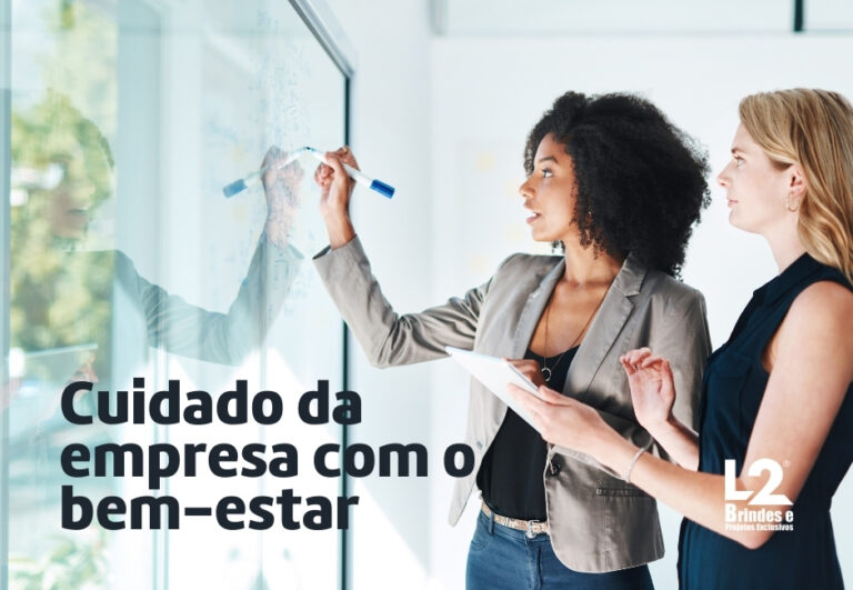 Duas mulheres de negócios colaboram em frente a um quadro de vidro, uma escrevendo e a outra segurando um tablet, com o texto Cuidado da empresa com o bem-estar e o logo L2 Brindes.