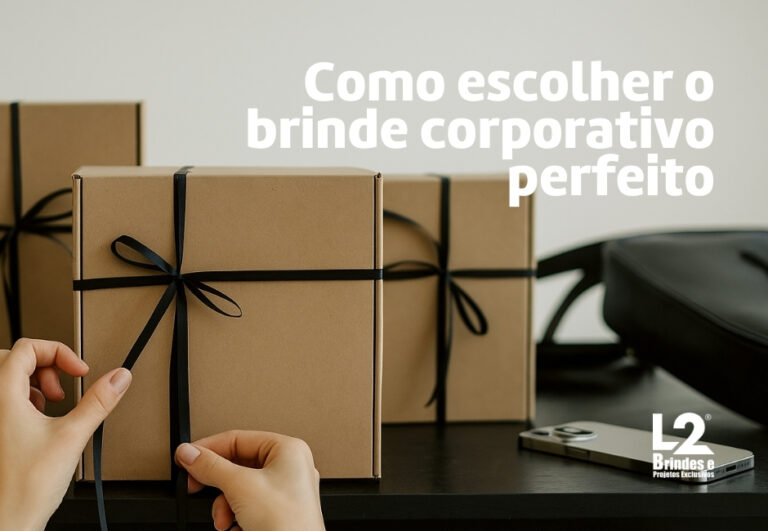 Mãos amarrando fita preta em caixas de papel kraft, simbolizando brindes corporativos personalizados sobre mesa de escritório.